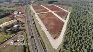 Vista aérea de um terreno com campos agrícolas e vegetação ao redor.