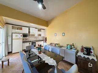 Vista de uma sala de jantar integrada a uma cozinha em imóvel no Brasil.