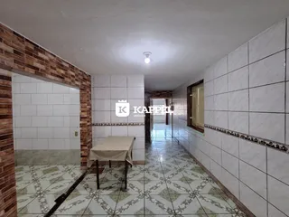 Corredor interno com piso de azulejos e paredes de tijolo aparente.