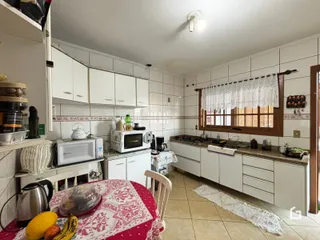 Foto de uma cozinha com armários brancos e piso de cerâmica.