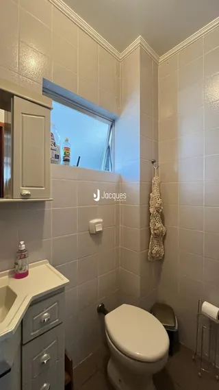 Foto de um banheiro interno com azulejos brancos e vaso sanitário.