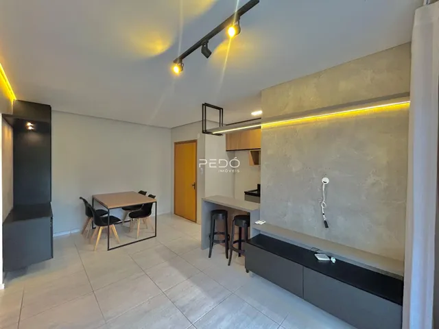 Sala de estar com cozinha integrada e mesa de jantar em um imóvel em Lajeado.
