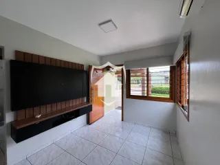 Sala de estar com painel de madeira e piso cerâmico claro.