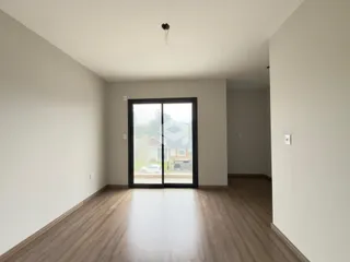 Ambiente interno com piso de madeira e porta de vidro.