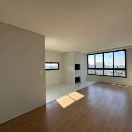 Sala de estar com piso de madeira e grande janela com vista urbana.