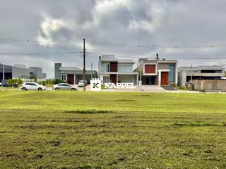 Foto da fachada de casas modernas em um terreno com gramado verde.