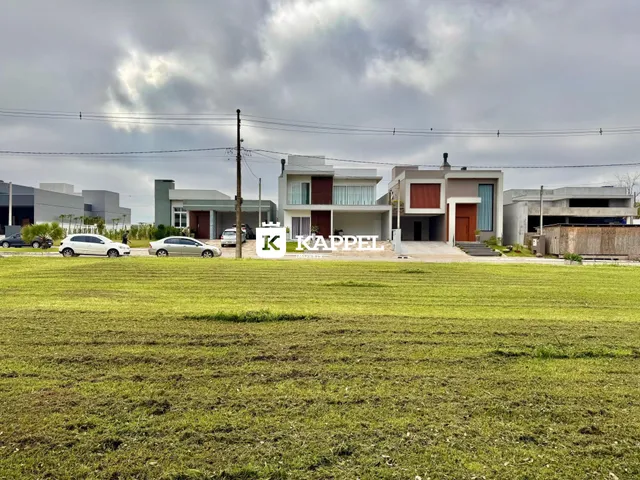 Foto da fachada de casas modernas em um terreno com gramado verde.