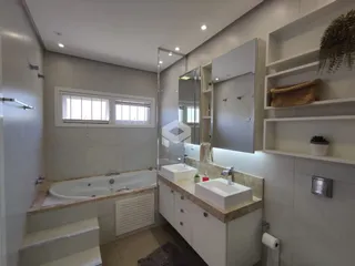 Foto de um banheiro com banheira e bancada em um imóvel.