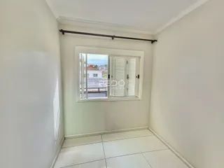 Interior de um corredor com janela de madeira.