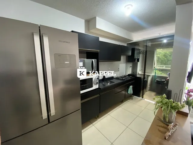 Cozinha moderna com eletrodomésticos em aço inoxidável e piso cerâmico.