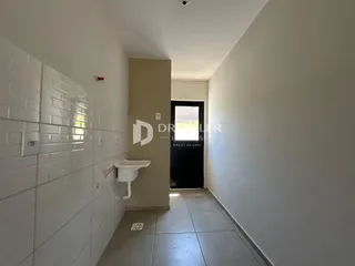 Parede com azulejos brancos e piso de cerâmica em um corredor.