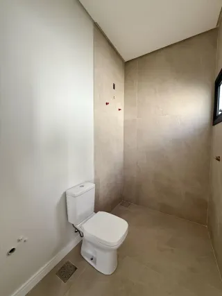 Foto de um banheiro com piso e paredes claros.