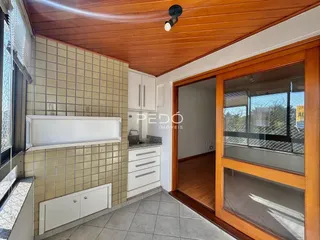 Esta é uma vista interna de uma cozinha com revestimento de azulejo e teto de madeira.
