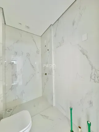 Um banheiro com revestimento de mármore branco.