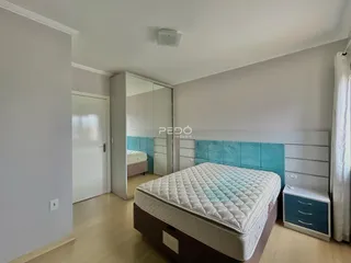 Quarto com cama e parede azul turquesa em imóvel no Brasil.