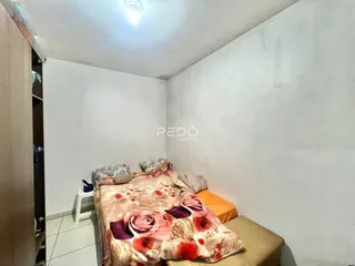 Quarto com cama e paredes brancas na residência.