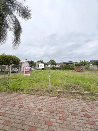Vista externa da propriedade mostrando gramado e cerca no primeiro plano.