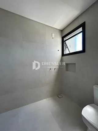 Interior de um ambiente com paredes cinzas e piso claro.