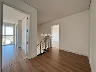Hall de entrada com piso de madeira clara e porta de acesso a outra área.