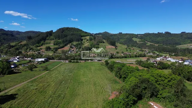 Vista aérea de paisagem rural com colinas verdes e campos no Brasil.