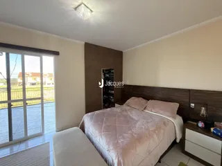 Quarto com cama e vista para o exterior em um imóvel em Lajeado.