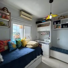 Quarto com cama azul e aparelho de ar-condicionado instalado.