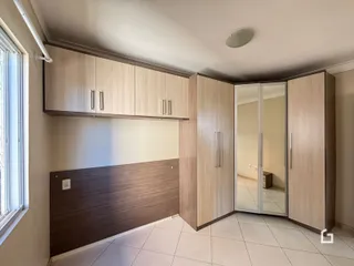 Interior de um ambiente com armários de madeira e piso cerâmico.