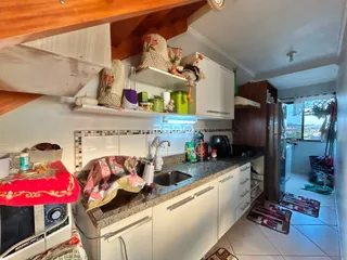 Foto da cozinha de uma propriedade em Lajeado, Brasil, mostrando armários brancos e bancada.