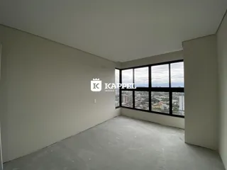 Ambiente interno vazio com grande janela mostrando a paisagem da cidade.