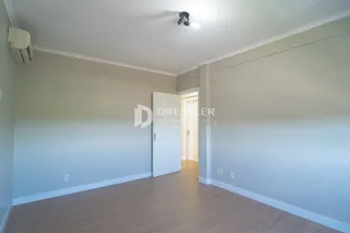 Ambiente interno com piso de madeira e paredes claras.