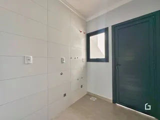 Vista interna de uma parede com acabamento liso e porta de entrada.
