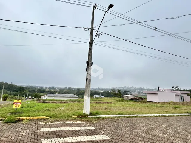 Vista externa de uma propriedade com poste e vegetação no primeiro plano.