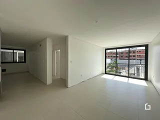 Ambiente interno de uma sala ampla com piso de cerâmica clara.