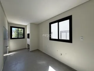 Ambiente interno com paredes claras e piso cinza.