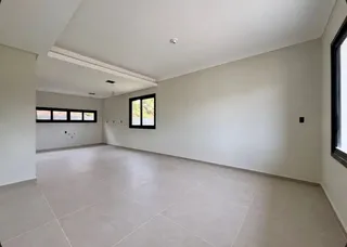 Sala ampla com piso de porcelanato e janelas.