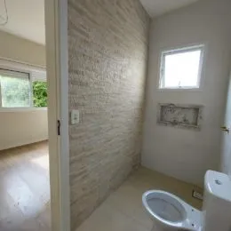 Foto interna de um ambiente com piso de cerâmica e uma janela.