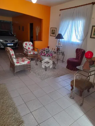 Sala de estar com móveis de vime e piso cerâmico.