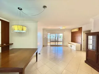 Ambiente interno de uma sala de estar com piso de cerâmica e portas de vidro para o exterior.