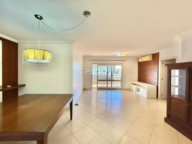 Ambiente interno de uma sala de estar com piso de cerâmica e portas de vidro para o exterior.