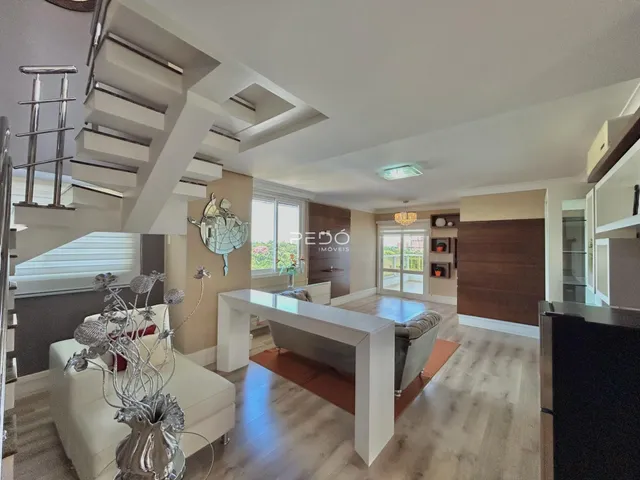 Sala de estar com piso de madeira clara e escadaria moderna.