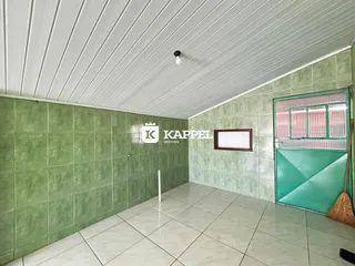 Foto de um corredor interno com piso de cerâmica clara e paredes verdes.