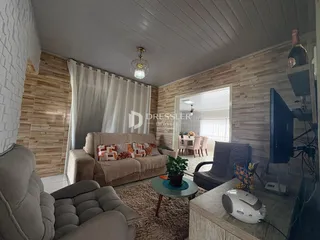 Sala de estar com sofá e poltrona em ambiente com painéis de madeira.