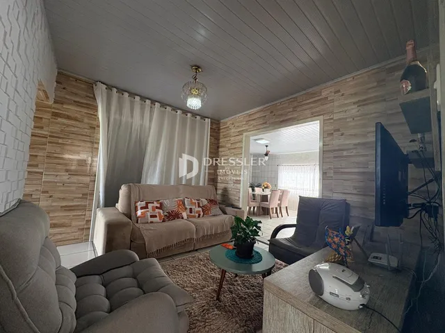 Sala de estar com sofá e poltrona em ambiente com painéis de madeira.
