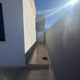 Foto de um corredor estreito com paredes brancas em uma propriedade.