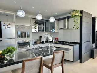 Interior de uma cozinha moderna com armários e bancadas escuras.