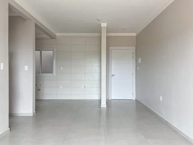 Hall de entrada com piso claro e paredes brancas.