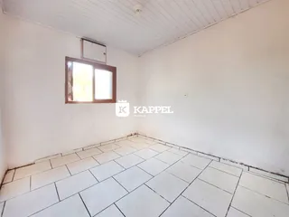 Foto de um cômodo interno com paredes brancas e piso de cerâmica.