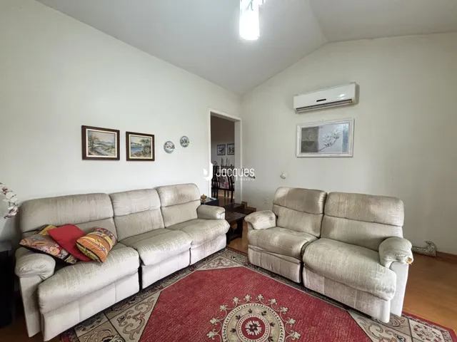 Sala de estar com sofás e tapete no interior da residência.