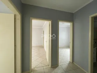 Vista de um corredor interno com portas abertas em uma residência.