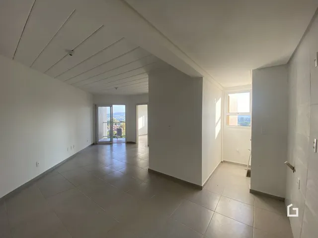 Interior de um cômodo com paredes brancas e piso de cerâmica.